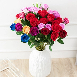 Detailed close-up of colorful artificial roses in a white ceramic textured vase