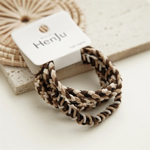 Detailed view of three braided hair ties in coffee, brown, and cream tones on a display card