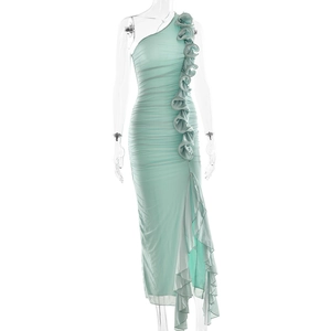 Detail of mint green one-shoulder dress featuring ruched mesh fabric and ruffle flower trims