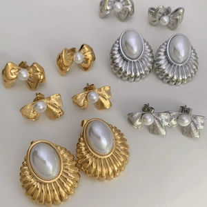 Detailed view of vintage bow and textured oval pearl earring set in gold and silver finish