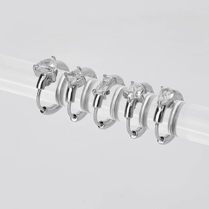 Set of five silver stainless steel hoop earrings with various zircon shapes on acrylic display