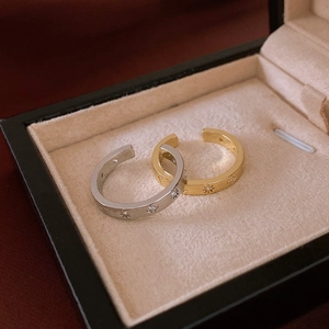 Macro shot of gold and silver brushed metal star rings with zircon inlay in a jewelry box