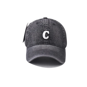 Détail de la broderie lettre C blanche sur une casquette en denim gris délavé