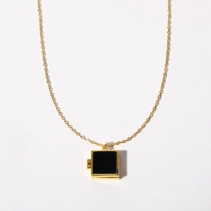 Detail of square black onyx locket pendant with gold-plated frame and vintage chain