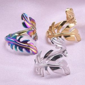 Detailed view of adjustable leaf rings in rainbow, gold, and silver stainless steel