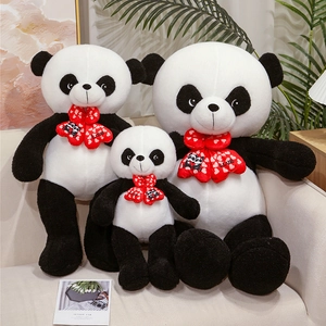 Three-piece panda plush toy set with red love bows sitting on a beige sofa decor
