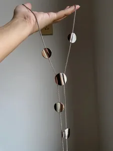 Detailed view of silver polished multi-disc pendant necklace with adjustable chain length