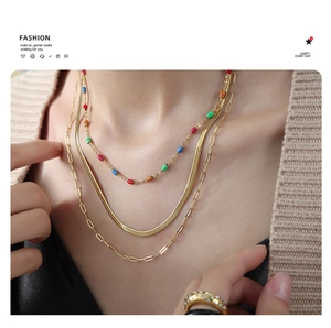 Vue détaillée d'un collier triple couche doré avec perles colorées et maille serpent