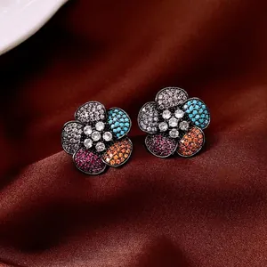Vintage silver needle flower stud earrings with colorful zircons on silk background