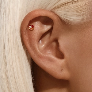Macro view of 16G s925 silver earring featuring a red heart with gold trim and tiny diamond