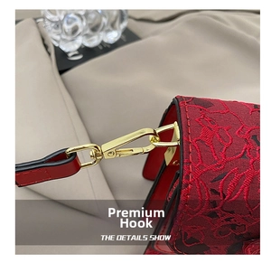 Detail of red and black lace texture with polished golden metal hook on casual handbag