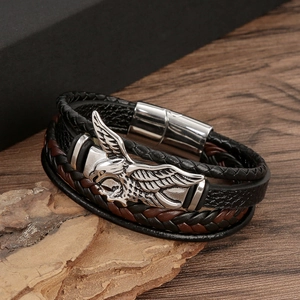 Detail of hand-woven leather bracelets featuring silver eagle magnetic clasp on wood