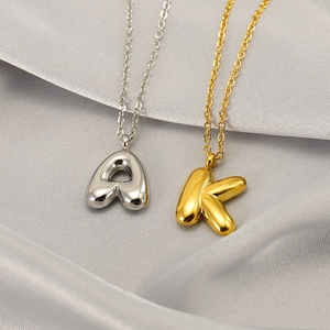 Colliers en acier inoxydable avec pendentifs lettres en or et argent sur tissu en soie grise