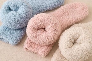 Detailansicht weicher, flauschiger Winter-Plüschsocken in den Farben Rosa, Blau und Beige