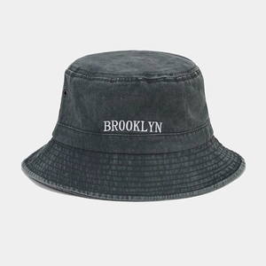 Détail de la broderie Brooklyn et des oillets métalliques sur le bob en coton délavé