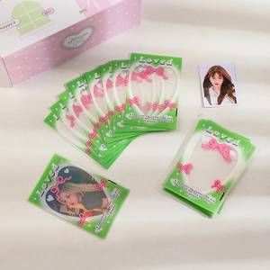 Gros plan de pochettes photo vertes avec nœuds roses et une mini boîte de rangement