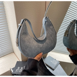 Detail of silver metal buckle on washed blue suede crescent hobo bag with side view
