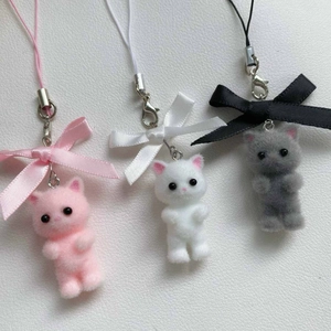 Close-up of cute flocked kittens with bowknots for Y2K phone and bag decoration