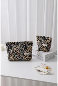 Macro view of floral jacquard fabric texture and brand label on a soft travel cosmetic bag
