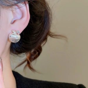 Close-up of 18K gold plated apple stud earring with zircon on model ear