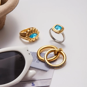Chic gold and silver ring set with light blue zircon stones on a white summer background