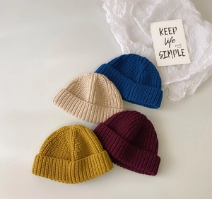 Detalle plano de gorros de punto en colores azul, beige, burdeos y amarillo