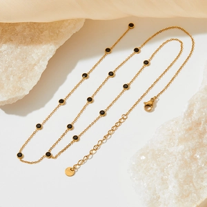 Detail of gold-plated stainless steel chain with black zircon stones and s.steel tag