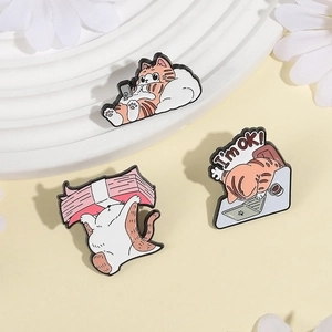 Cute orange cat enamel pin set on a white display stand with decorative white flowers