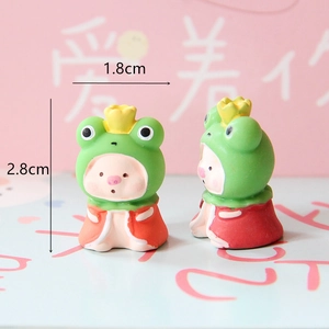Miniature resin pig figurines in green frog costumes with crowns for landscape decor