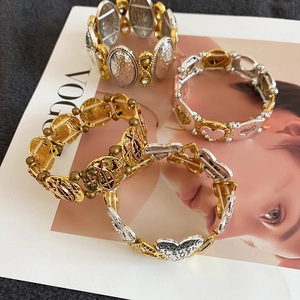 Detail view of heart-shaped gold and silver stretch bracelets with textured metal finish