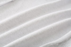 Detailed macro view of pure white soft cotton knit fabric with premium texture