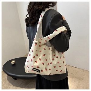 Detail shot of the corduroy fabric texture and cute strawberry print on the tote bag