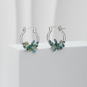 Detail of silver hoop earrings featuring colorful enamel butterfly and flower charms