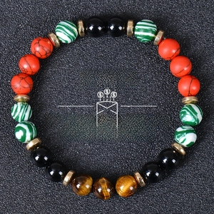 Detail of tiger eye and turquoise beads wealth bracelet with golden spacers on black leather