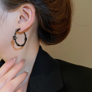 Detail of vintage gothic hoop earring with tiger eye stone and crystals on a model