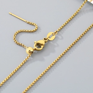 Macro view of adjustable gold box chain necklace with lobster clasp and slide bead detail