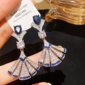 Macro shot of S925 silver fan-shaped earrings with blue pear-cut gemstones and diamonds