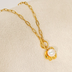 Detail of gold paperclip chain necklace with single pearl pendant and OT toggle clasp