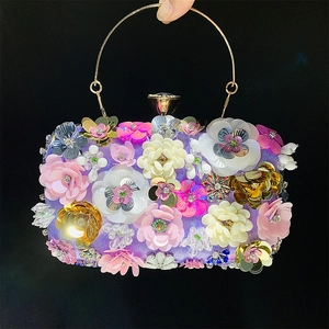 Detailed close-up of handmade floral beadwork and sequins on the purple evening clutch