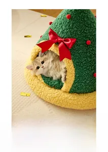 Dettaglio della cuccia a albero di Natale con peluche verde e grande fiocco rosso decorativo
