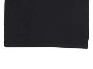 Vue macro détaillée montrant les coutures doubles précises sur l'ourlet de la robe noire
