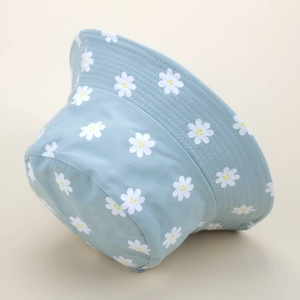 Close-up of white daisy floral print on light blue cotton fabric with detailed stitching