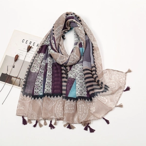 Detail view of multicolored paisley print scarf with fringe trim and cotton linen texture