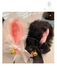 Close-up of plush cat ears headband featuring soft faux fur, satin bows, and gold bells