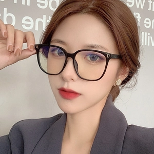 Close-up of black oversized square glasses frames with gold metallic D detail on the side