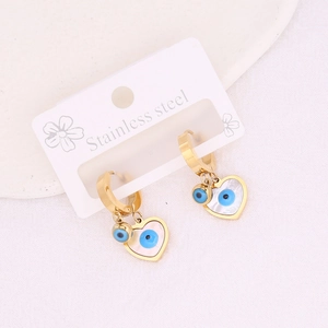 Detail shot of heart-shaped stainless steel earrings with evil eye motif on packaging