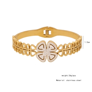 Detailed view of stainless steel flower bangle with white crystals and hollow clover design