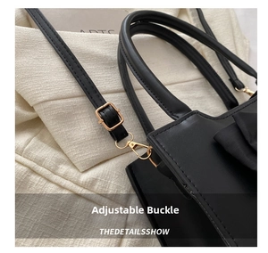 Detail of adjustable black leather strap with gold metal buckle and lobster clasp
