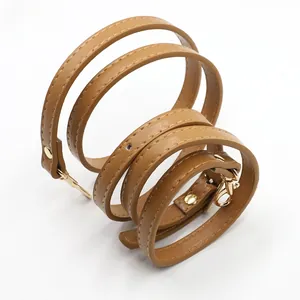 Close-up of brown PU leather bag strap with neat stitching and gold metal swivel hooks