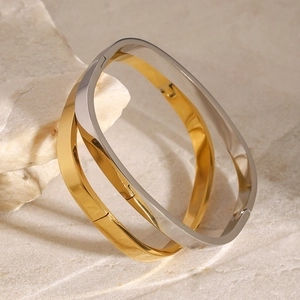 Interlocked gold and silver stainless steel square clasp bracelets on stone